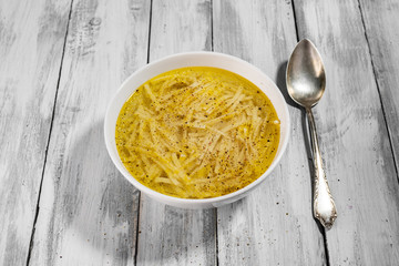 Domowy rosół na stole z desek z rustykalna łyżką © piotrszczepanek