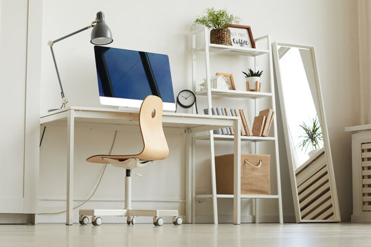 Low Angle View At All-white Home Office Workplace With Wooden Chair And Modern Computer On Desk, Copy Space