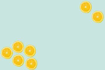 a selection of cut oranges laid out on a light green background with a place for inscription