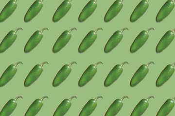 patterns of delicious jalapeno peppers on green background