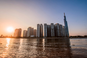 Obraz premium Aerial view of Ho Chi Minh City skyline and skyscrapers in center of heart business at Ho Chi Minh City downtown. Panorama of cityscape on Saigon river in Ho Chi Minh City at Vietnam at sunset scene
