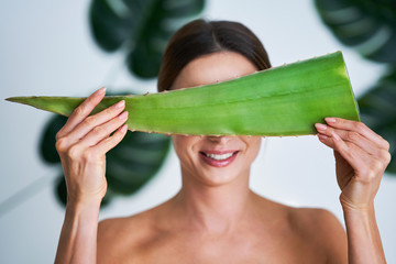 Beautiful adult woman posing against leaf background