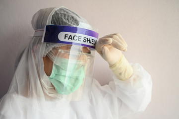 Nurse having headache and tired while wearing PPE suit for protect coronavirus disease. PPE while...