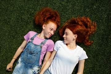 Two happy teens on green grass