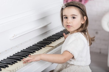 Beautiful young little girl playing the piano