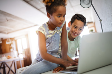 Game, study, fun concept. Happy children spending time with notebook and modern technology.