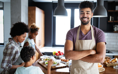 Happy family in the kitchen having fun and cooking together. Healthy food at home.