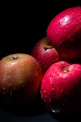 red apples with drops of water on a black background
