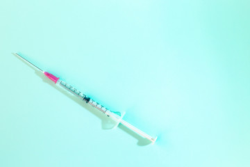 isolated syringe and vaccine on blue background with copy space