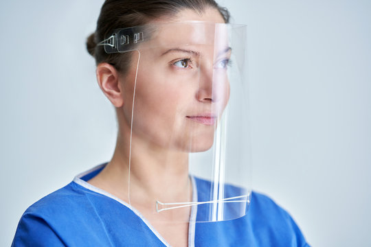 Close Up Portrait Of Female Medical Doctor Or Nurse Wearing Face Shield