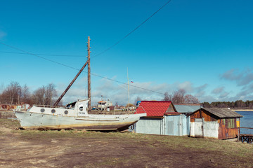 Fototapeta na wymiar old iron boat by the river near the boathouses