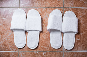 Hotel slippers on tile background