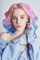 Portrait of a woman with bright colored flying hair, all shades of purple. Hair coloring, beautiful lips and makeup. Hair fluttering in the wind. Sexy girl with short  hair. Professional coloring