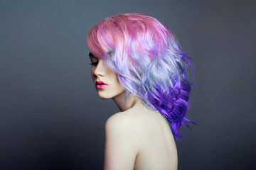 Portrait of a woman with bright colored flying hair, all shades of purple. Hair coloring, beautiful...