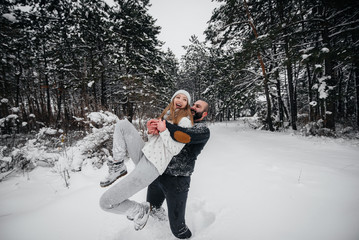 Couple playing with snow in the forest