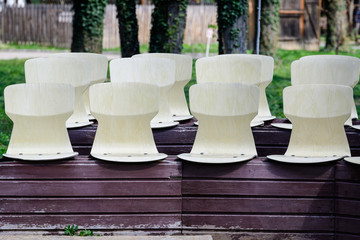 Empty old rusted white chairs in a sunny summer day in a park in Bucharest, Romania
