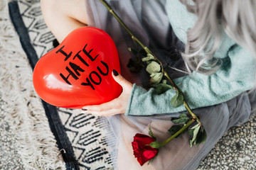 Woman holding I Hate You balloon
