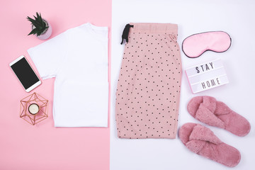 A t-shirt and sweat pants on pink and white background.  Flat lay, top view. 