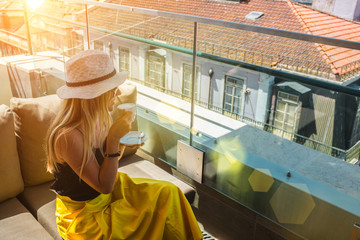 Young traveler woman with smartphone sitting cafe in Lisbon and takes pictures of city. Beautiful...