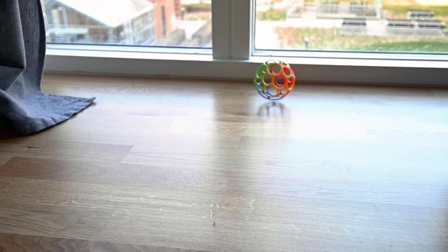 Colourful toy plastic ball rolling over the floor in slow motion, stock footage by Brian Holm Nielsen