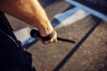 Police officer baton in hands. Policeman in action.