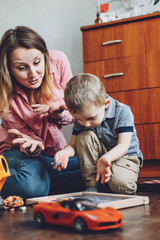 Obraz premium Happy mothers day Toddler Child son and mom play at home. Family games, holiday and togetherness. Keeping kids busy. Activities for children
