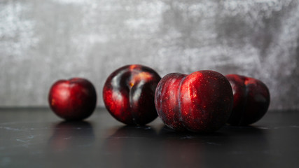 Red plum fruit on a black table.
