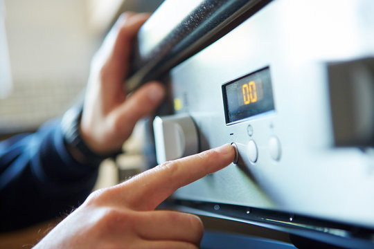 Man Starting A Microwave Oven For Cooking