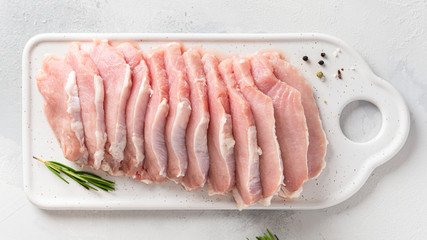 Raw pork meat. Fresh steaks on white board on white background. Top view. Dieting, nutrition
