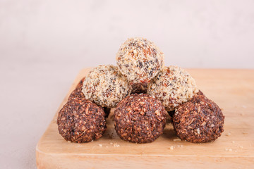 Homemade Raw energy balls with nuts, banana and coconut flakes with ingredients on a wooden board.