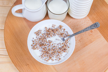 Top view of buckwheat porridge with milk and dairy products