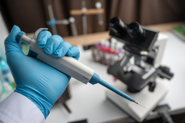 Medical equipment Blood test. Pipette adding fluid to one of several test tubes