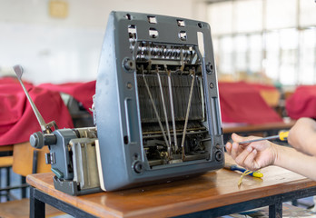 Close up photo of vintage manual typewriter being fixed by a repairman
