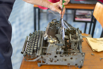 Close up photo of vintage manual typewriter being fixed by a repairman
