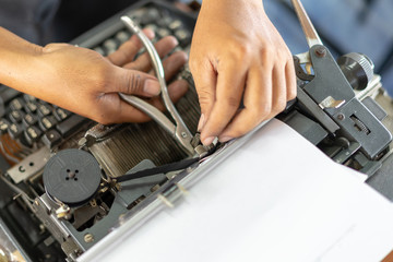 Close up photo of vintage manual typewriter being fixed by a repairman
