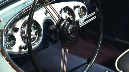 Close-up of black-metal steering wheel of vintage vehicle. Classic retro style