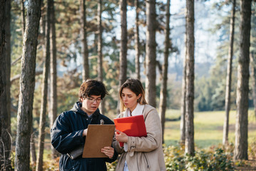 Fototapeta premium Scientists are studying plant species and inspect trees in the forest.