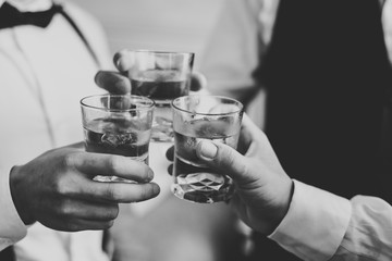 Business meeting. Men hold glasses of whiskey. Men's Party. Hand with a drink of alcohol