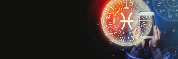Female hands are holding a phone and an astrological circle with the zodiac sign Pisces on a background of the starry sky. Mobile Application for the horoscope. Banner. Copy space