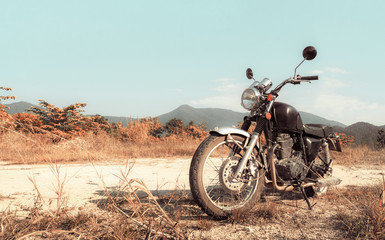 Fototapeta na wymiar Motorbike under sky. Vintage color photo effect added