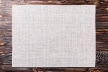 Top view of empty white table napkin for dinner on wooden background with copy space