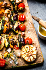 Serving Grilled BBQ Vegetables Skewers with Fresh Herbs, Marinate and Spices on Wooden Board