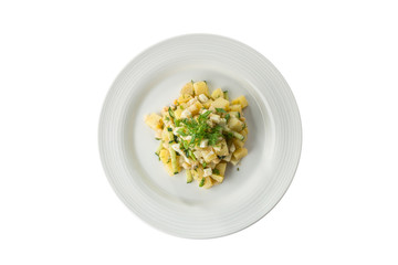 Traditional German potato salad with cucumber, onion, egg and mayonnaise on white plate isolated on...