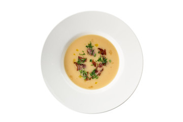Pumpkin cream soup with bacon on white plate isolated on white background