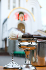 The blessed goblet and spray are prepared for worship on the table in the Orthodox Church. Blurred background of the temple, the inscription ХV Risen. The concept of Orthodoxy.