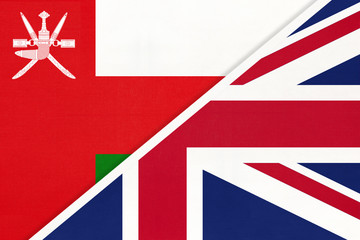 United Kingdom vs Oman national flag from textile. Relationship between two european and asian countries.