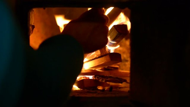 Firewood burns hot in a rustic stove. The old village in the Russian province. 