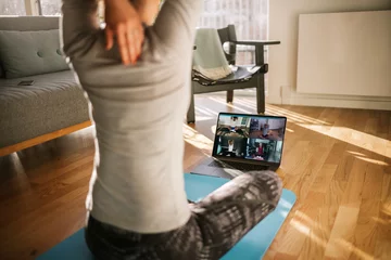  Fitnesscoach die yoga online geeft aan een groep mensen © Jacob Lund