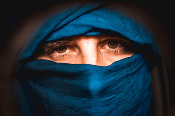 Simulation of a Berber covered in blue cloth in the desert of Merzouga in Morocco