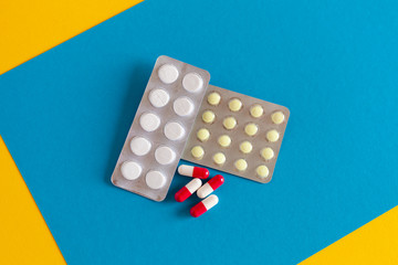 red-white pills and tablets in a blister pack on a blue background
